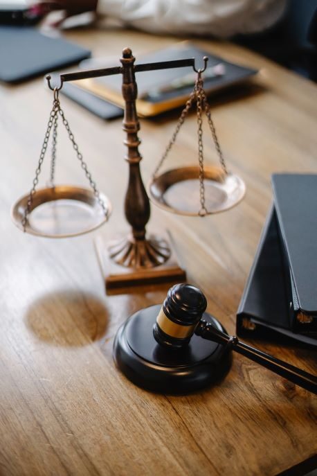 Miniature scales sit on a desk next to a gavel.